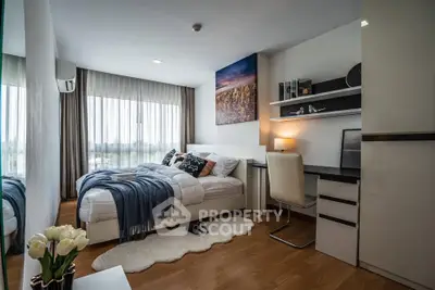 Modern bedroom with stylish decor and natural light, featuring a cozy bed and workspace.