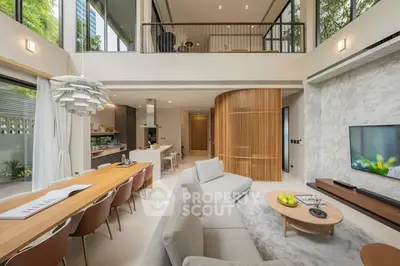 Luxurious open-plan living room with modern design and high ceilings, featuring elegant furniture and natural light.