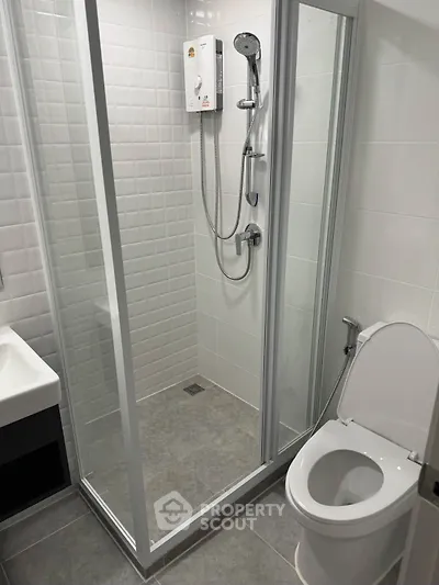 Modern bathroom with glass shower enclosure and sleek fixtures.
