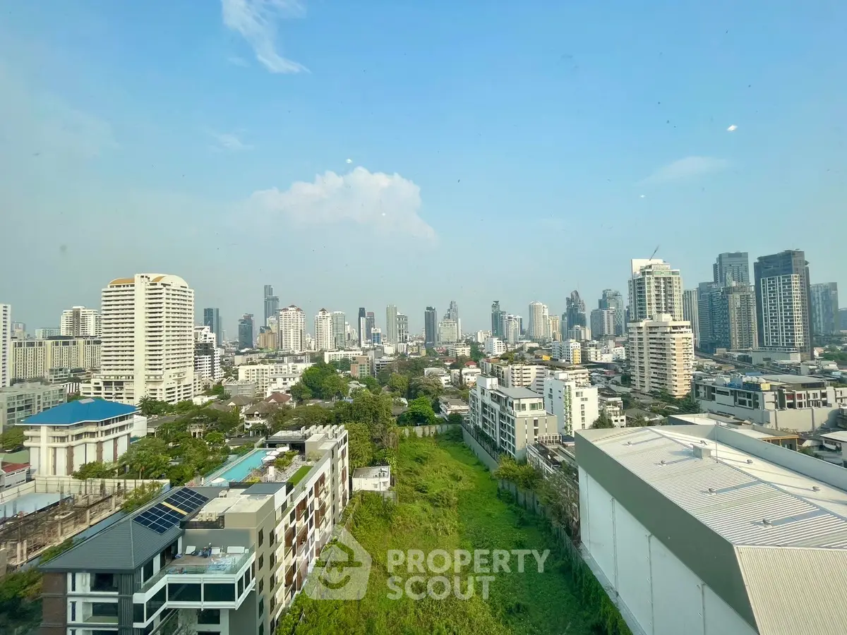 Stunning cityscape view from high-rise building showcasing urban skyline and lush greenery.