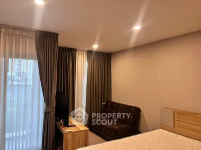 Cozy bedroom with modern decor, featuring a comfortable bed, stylish curtains, and a sleek TV setup.