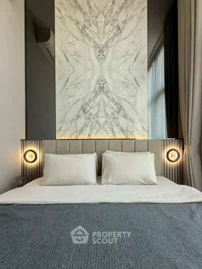 Luxurious bedroom with elegant marble accent wall and modern lighting
