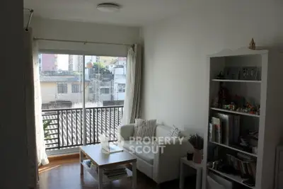 Bright living room with large window and cozy seating area, perfect for relaxation.