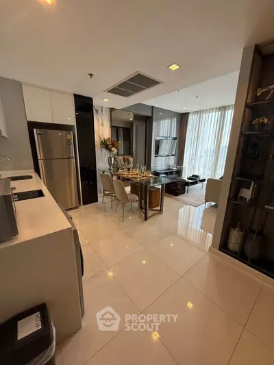 Modern open-layout kitchen and living room with elegant dining area and natural light.