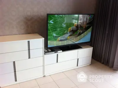 Modern living space featuring sleek white media console with ample storage, complemented by a large flat-screen TV, set against a textured wallpaper backdrop.