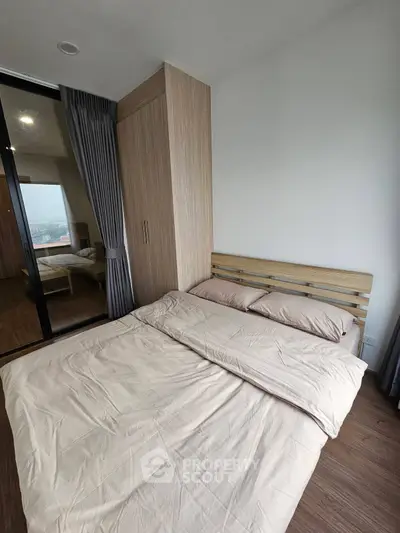 Modern bedroom with wooden flooring and large wardrobe, featuring a cozy bed and floor-to-ceiling windows.