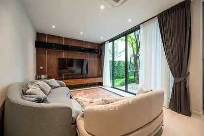 Stylish living room with modern furniture and large window view to garden.