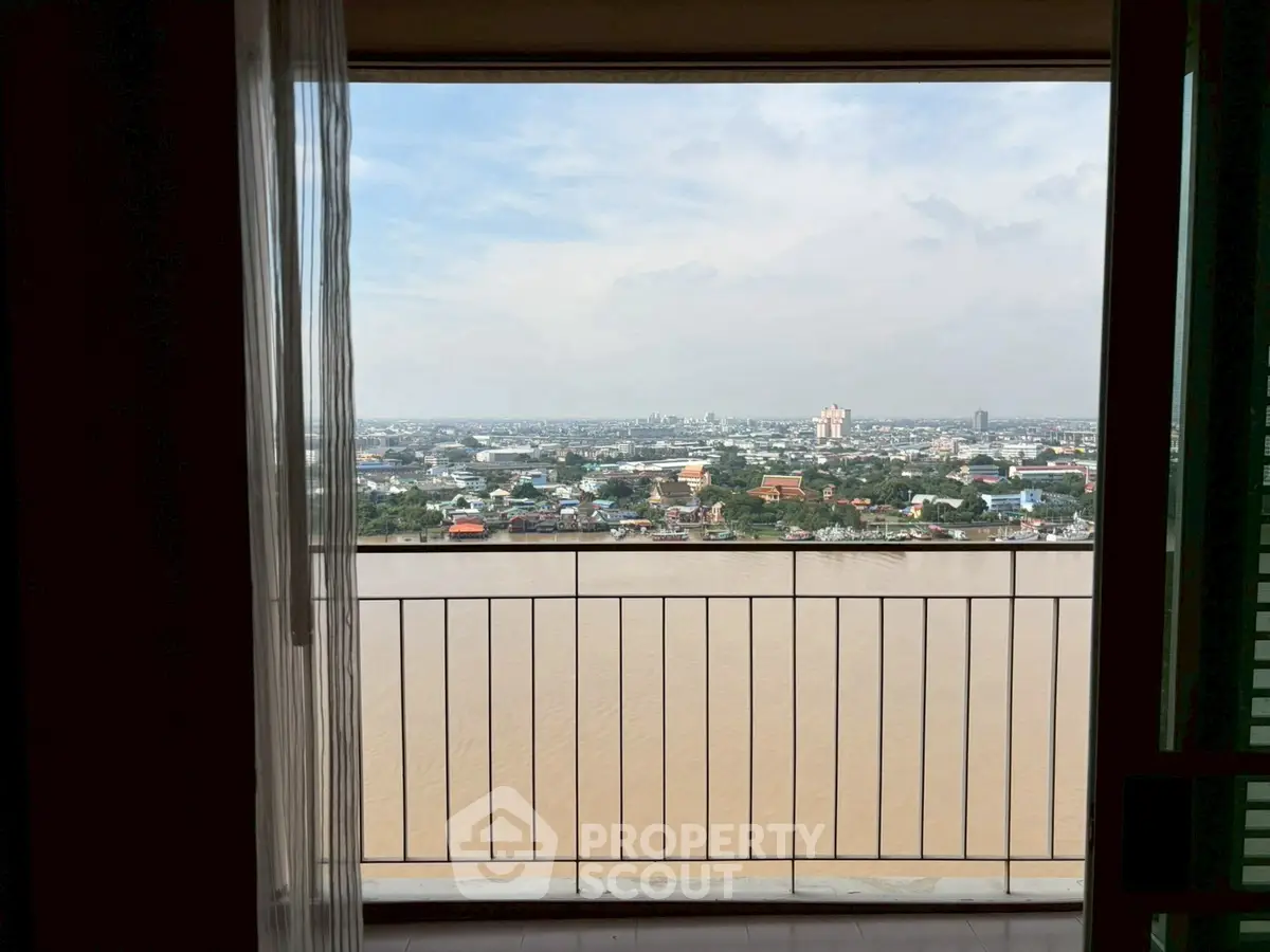 Stunning river view from high-rise balcony overlooking cityscape.