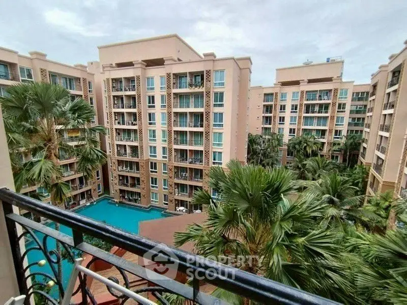 Stunning view of modern apartment complex with lush greenery and inviting pool area.