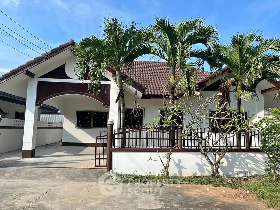 Charming single-story home with lush palm trees and spacious driveway