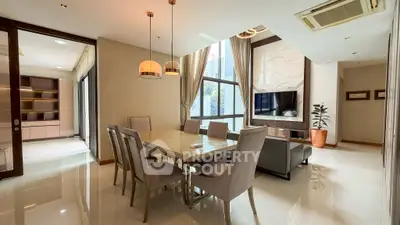 Luxurious open-plan dining and living area with modern decor and natural light.