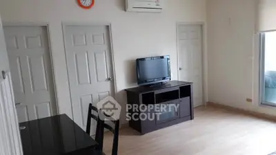 Modern living room with TV and dining area, featuring sleek furniture and minimalist design.