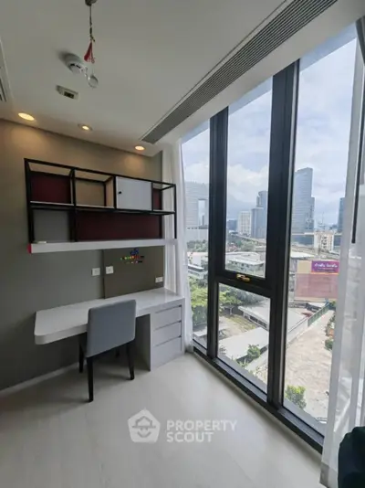 Modern study room with city view, featuring sleek desk and floor-to-ceiling windows in urban apartment.