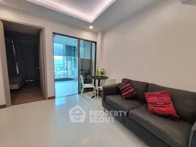 Modern living room with cozy sofa and dining area, featuring large windows for natural light.