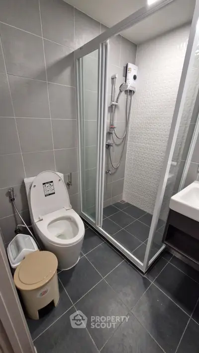 Modern bathroom with sleek shower and toilet in contemporary design.