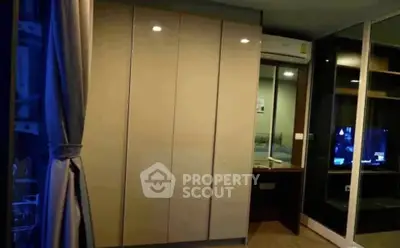 Modern bedroom with sleek wardrobe and air conditioning, featuring a cozy ambiance.