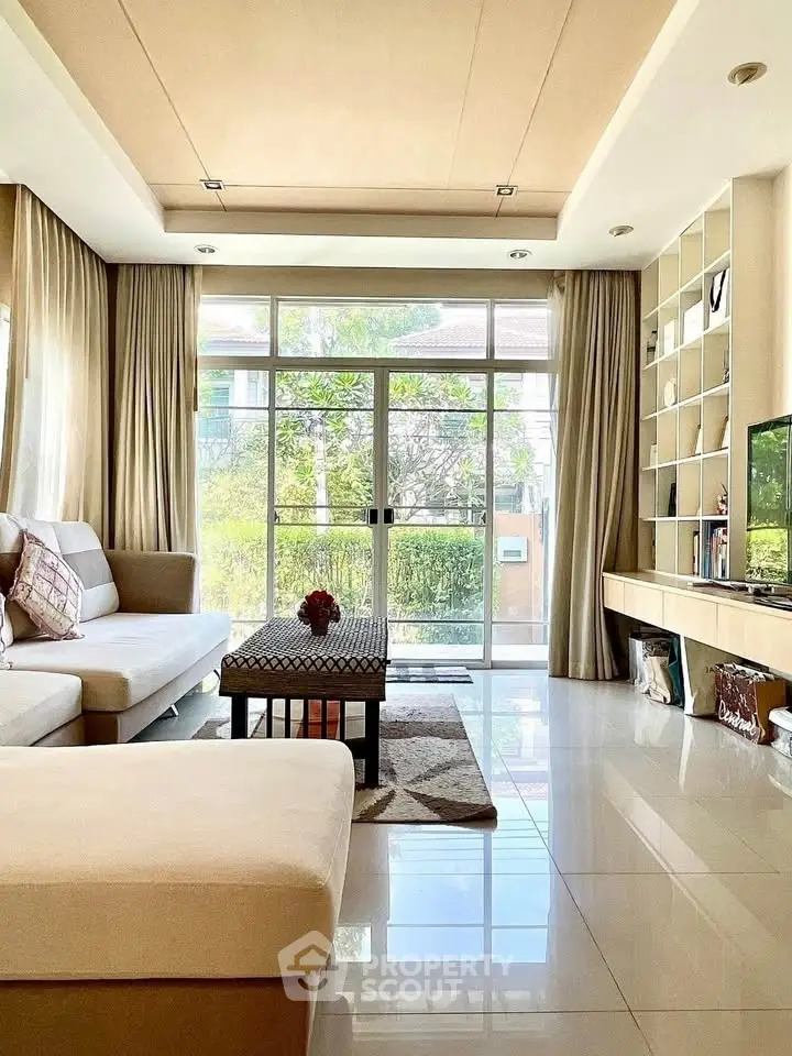 Spacious living room with modern decor and large windows offering natural light.