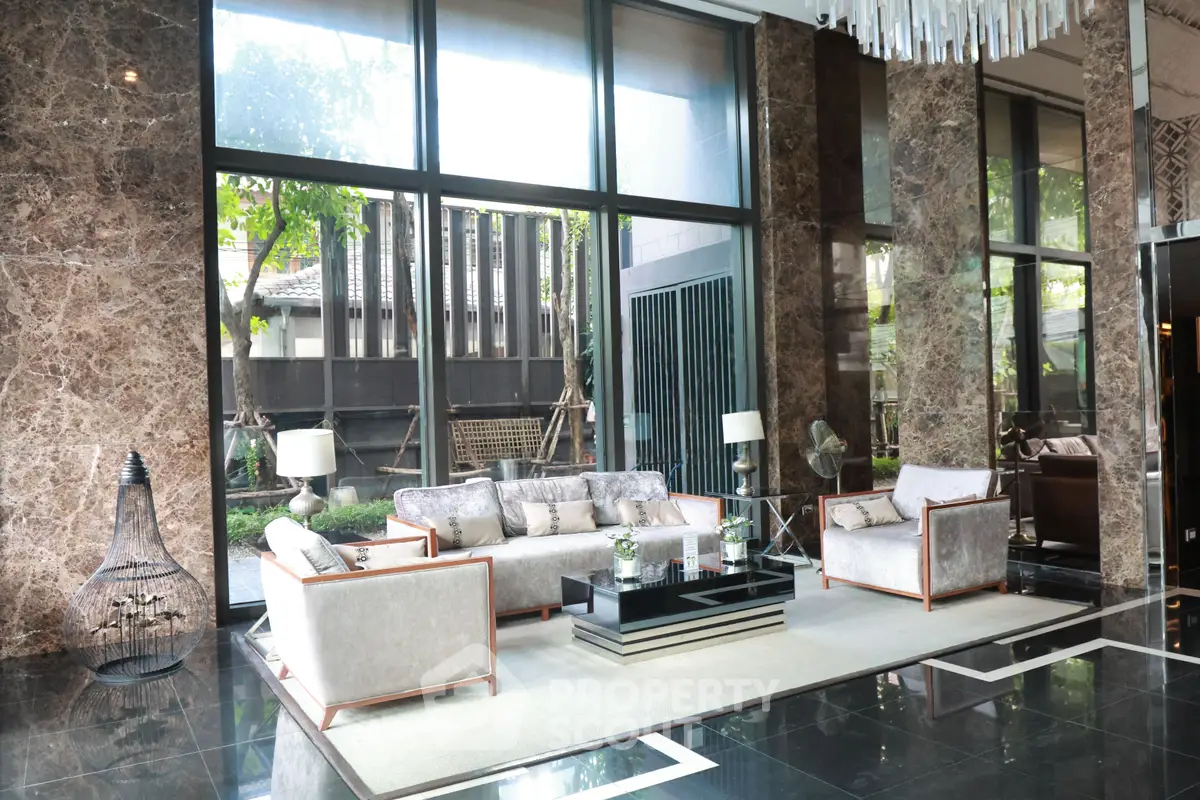 Luxurious lobby with elegant seating and floor-to-ceiling windows offering garden views.