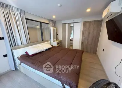 Modern bedroom with cozy bed, wall-mounted TV, and stylish decor in a contemporary apartment.