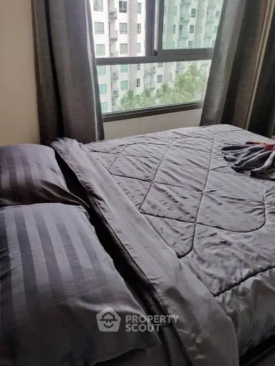 Cozy bedroom with modern bedding and city view from window