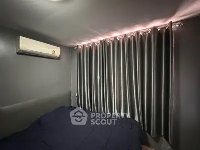 Cozy bedroom with dark curtains and air conditioning, perfect for restful nights.