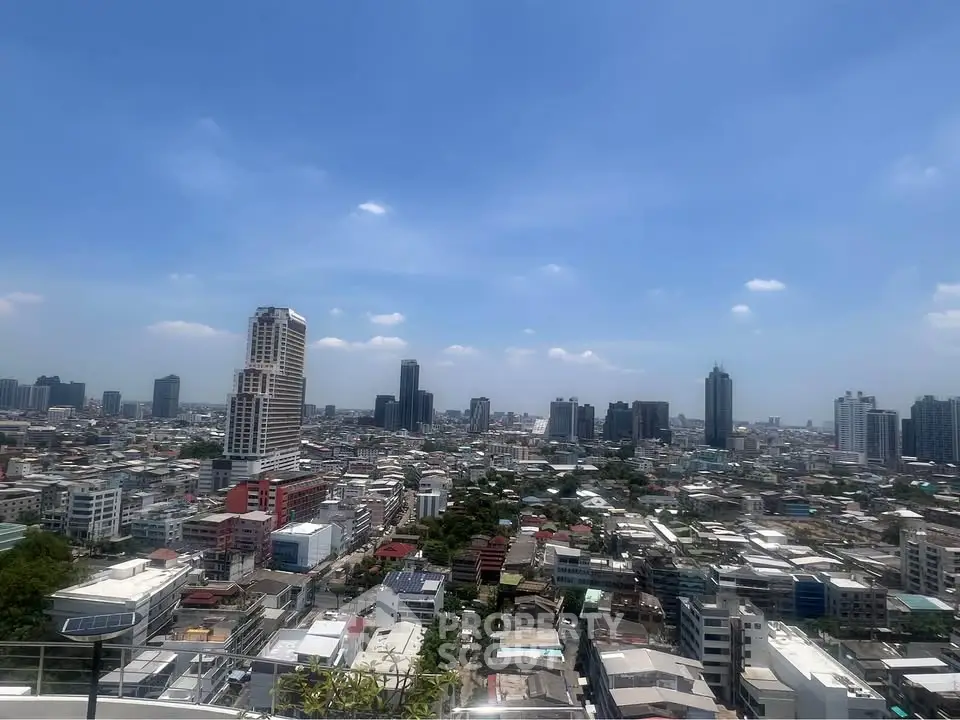 Stunning cityscape view from a high-rise building showcasing urban skyline under a clear blue sky.