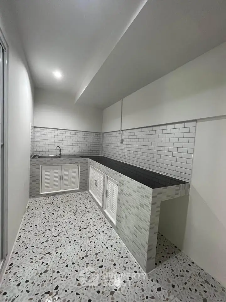 Modern kitchen with sleek white cabinetry and stylish tiled backsplash