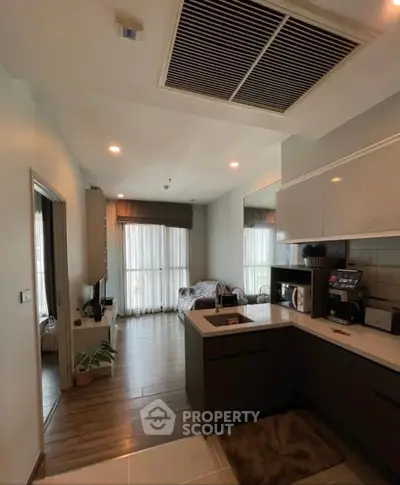 Modern open-layout kitchen with sleek cabinetry and cozy living area, perfect for urban living.