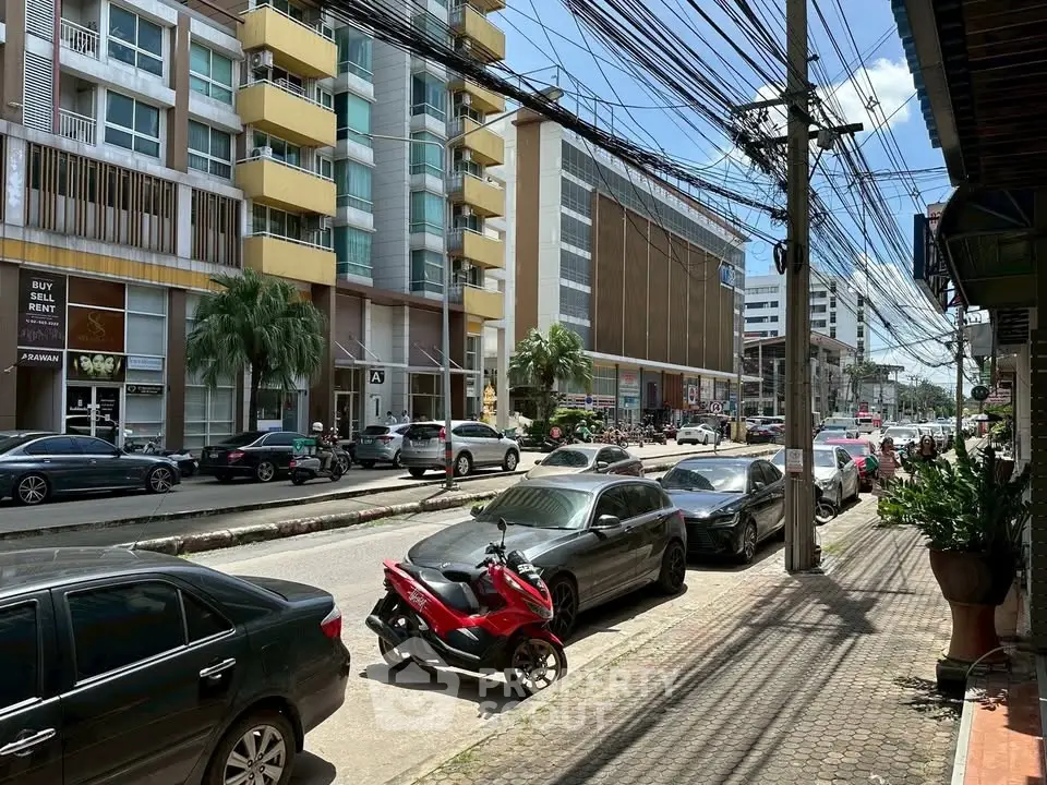 Bustling urban street view with modern buildings and parked cars, ideal for city living.