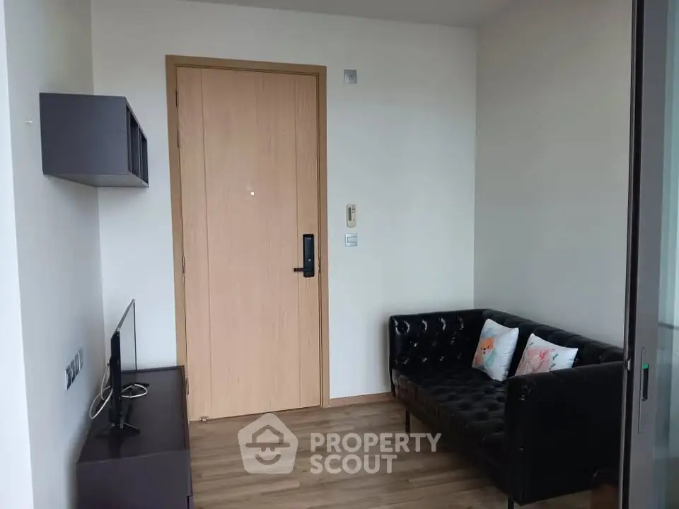 Cozy living room with modern black sofa and wooden flooring