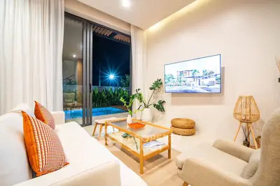 Modern living room with cozy seating and pool view, perfect for relaxation.