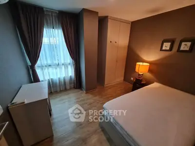 Cozy bedroom with wooden flooring and ambient lighting in modern apartment