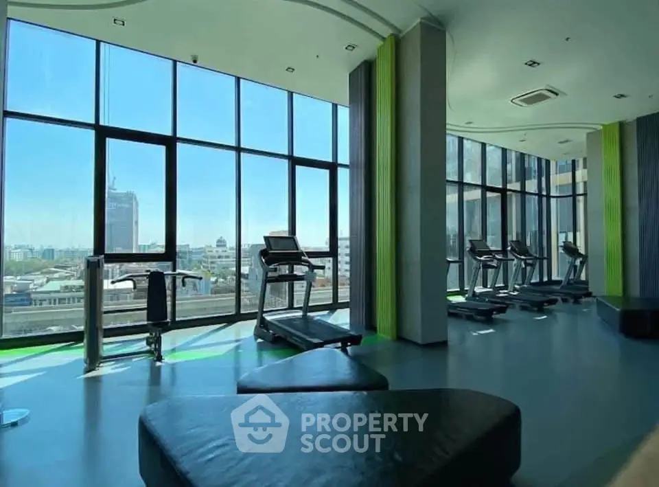 Modern gym with panoramic city views and state-of-the-art equipment in a luxury high-rise building.