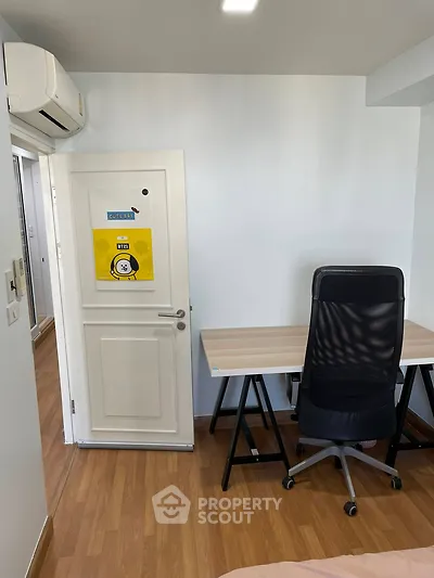 Modern study room with sleek desk and ergonomic chair, featuring wooden flooring and air conditioning.