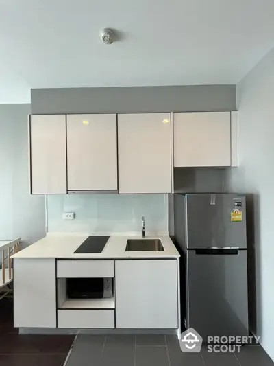 Modern kitchen with sleek cabinetry and stainless steel fridge in stylish apartment