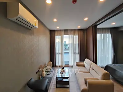 Modern living room with cozy sofa and large windows, perfect for relaxation.