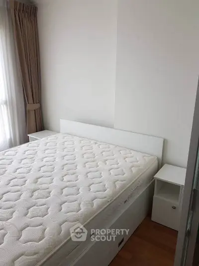 Spacious bedroom with natural light and modern furnishings in a stylish apartment.