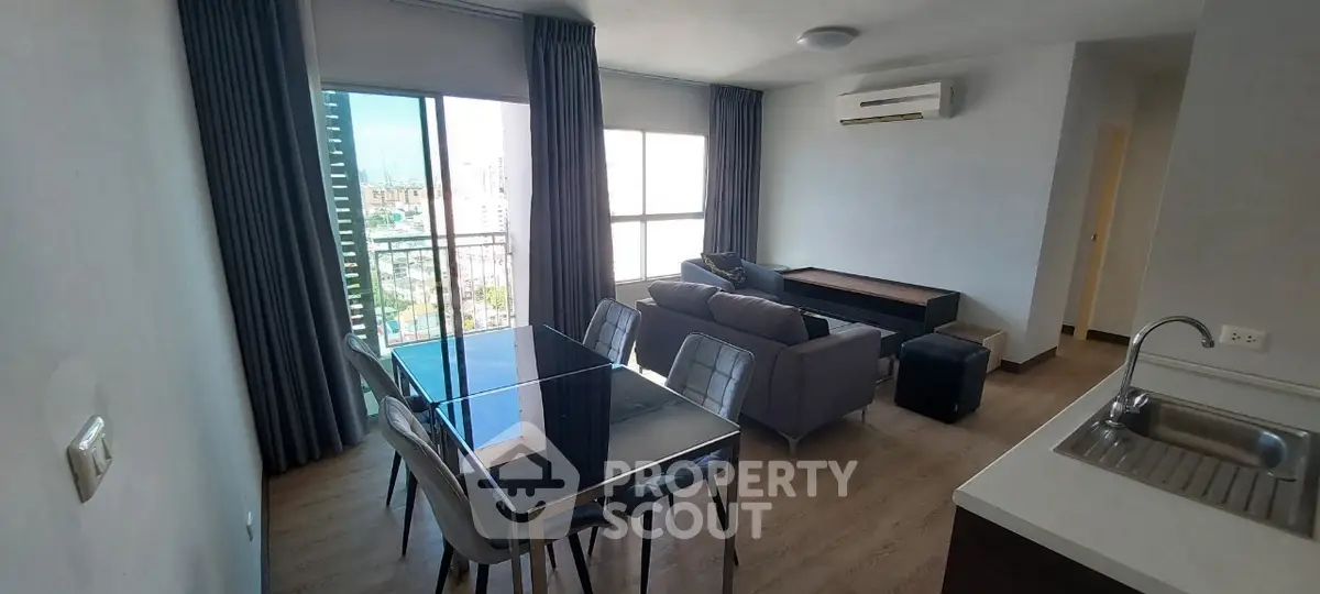 Modern living room with dining area and large windows offering city views