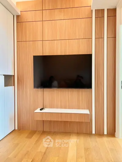Modern living room with sleek wooden paneling and wall-mounted TV