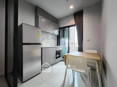 Modern kitchen with sleek cabinets, dining area, and balcony view in a stylish apartment.