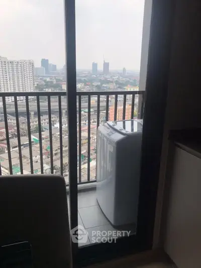 High-rise apartment balcony with city view and washing machine