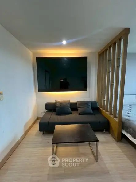 Modern living room with sleek black sofa and stylish partition wall