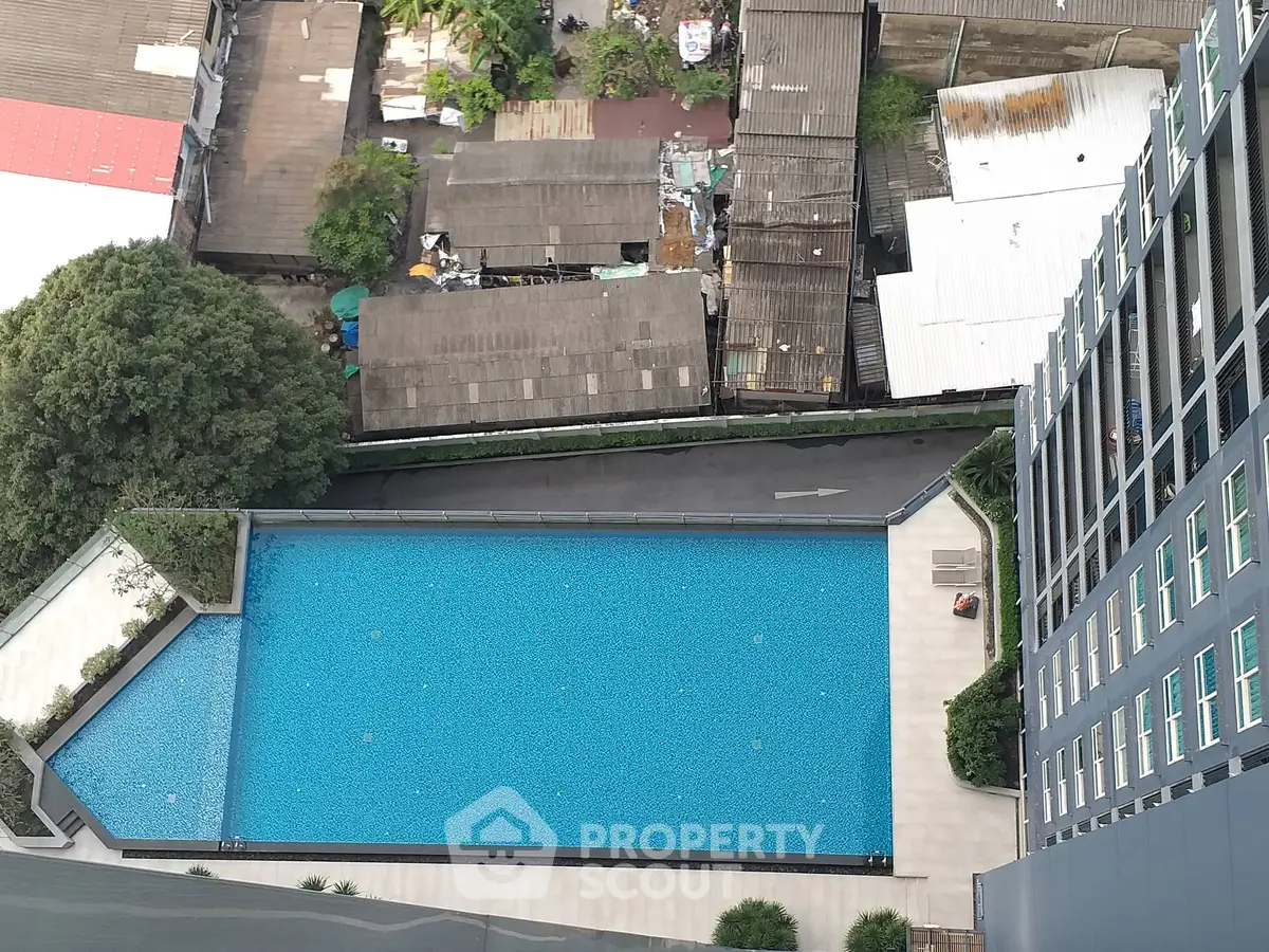 Stunning aerial view of modern apartment pool with urban backdrop, perfect for city living enthusiasts.