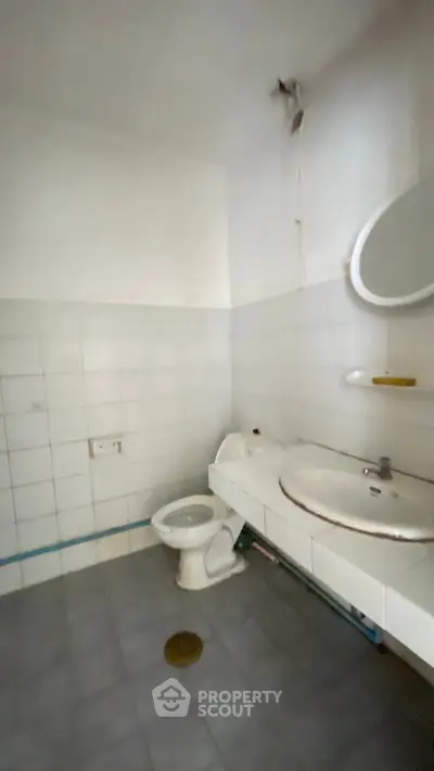 Spacious bathroom with modern fixtures and tiled walls, ideal for renovation projects.