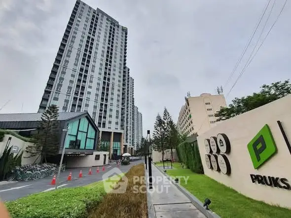 Modern high-rise condominium with landscaped entrance and sleek design.