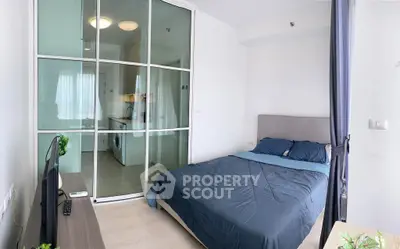 Modern bedroom with glass partition and in-unit laundry in a stylish apartment.