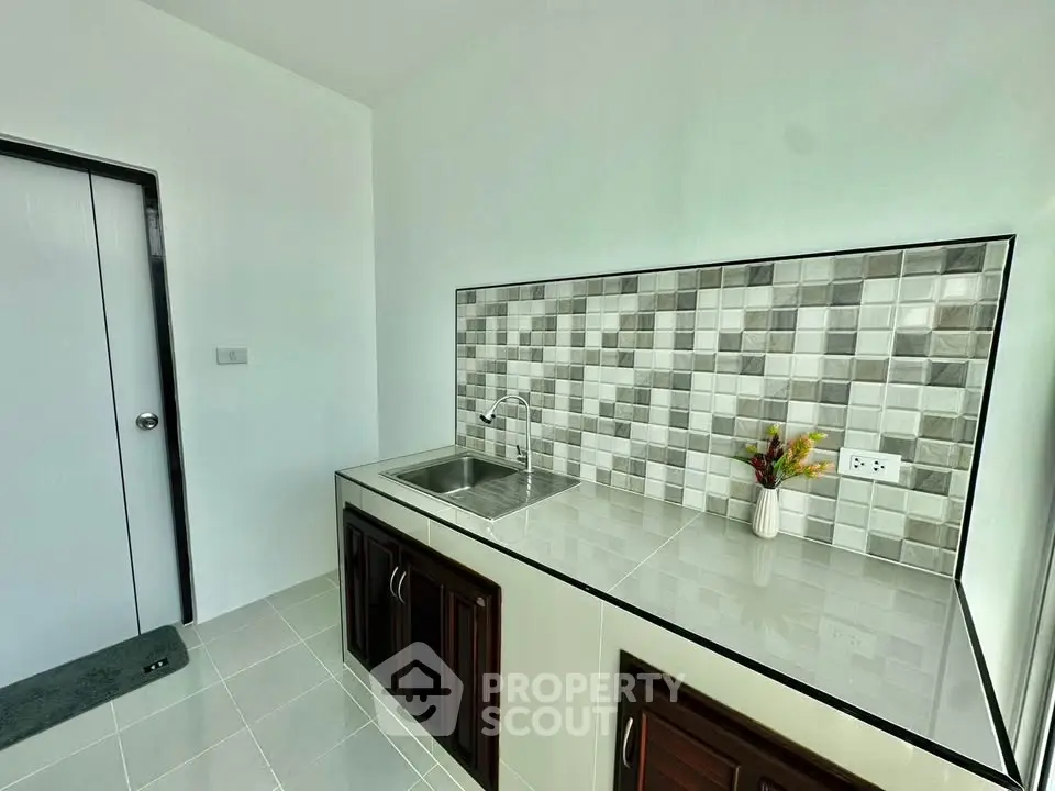 Modern kitchen with sleek countertops and stylish backsplash in a contemporary home.