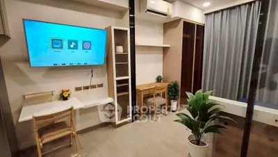 Modern living room with smart TV, desk, and stylish decor in a cozy apartment.