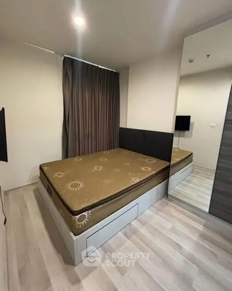 Modern bedroom with sleek design and mirrored wardrobe in a cozy apartment.