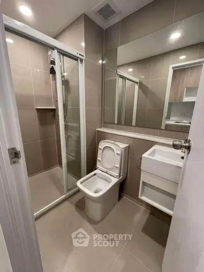 Modern bathroom with sleek shower and contemporary fixtures in a stylish apartment.